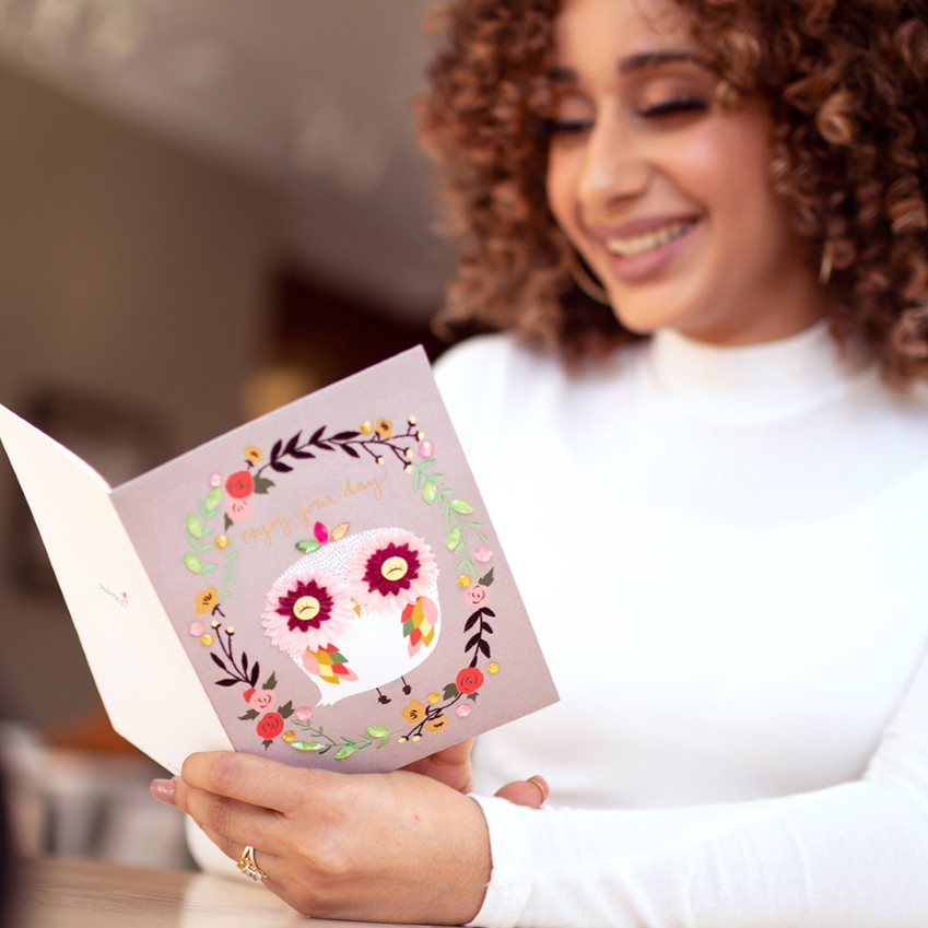 Woman holding floral owl birthday greeting card