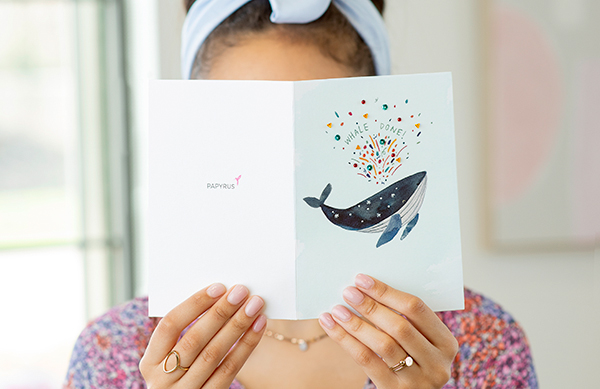 Woman holding whale done it card