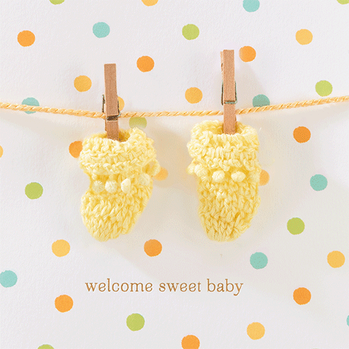 Yellow Baby Booties Hanging on Clothespin GIF