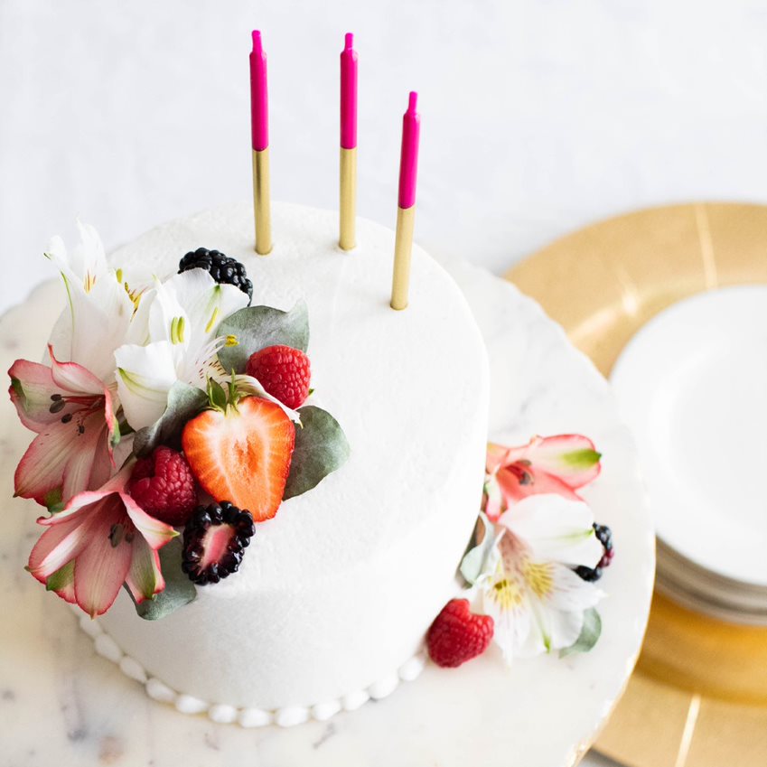 Cake with Flowers and Pink/Gold Candles on table