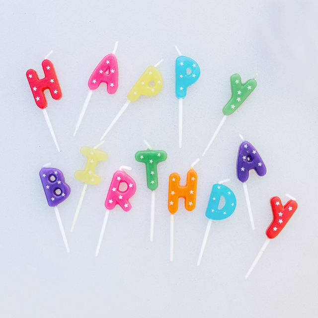 Happy Birthday Text Candles on table