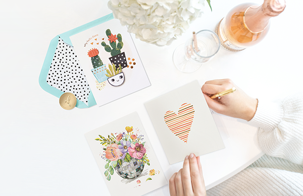 Hand with pencil with three greeting cards