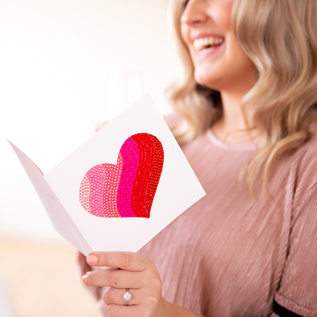 Woman reading Valentine's Day gem heart card