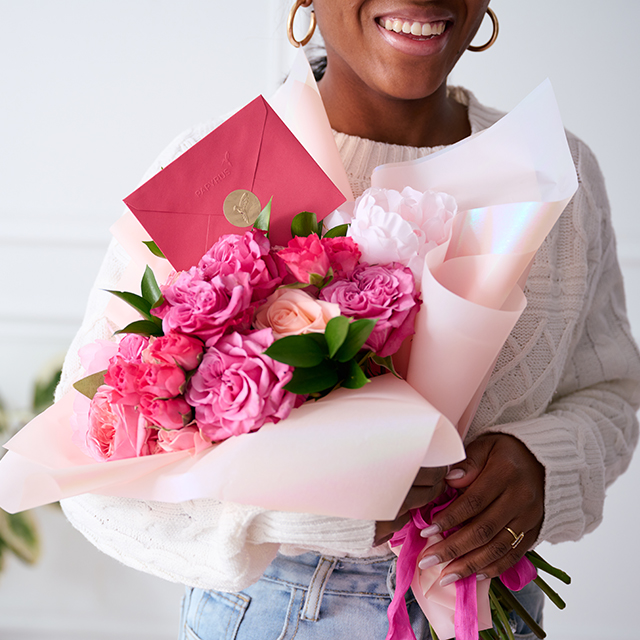 Girl holding flowers and a valentine's day card