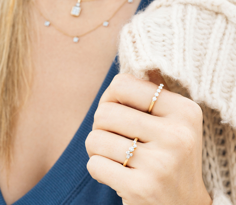 A female wearing diamond rings and necklaces.