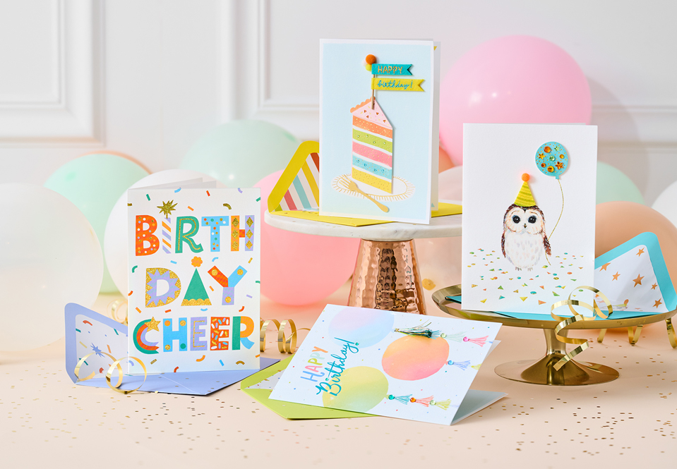 A group of birthday cards on a table with balloons