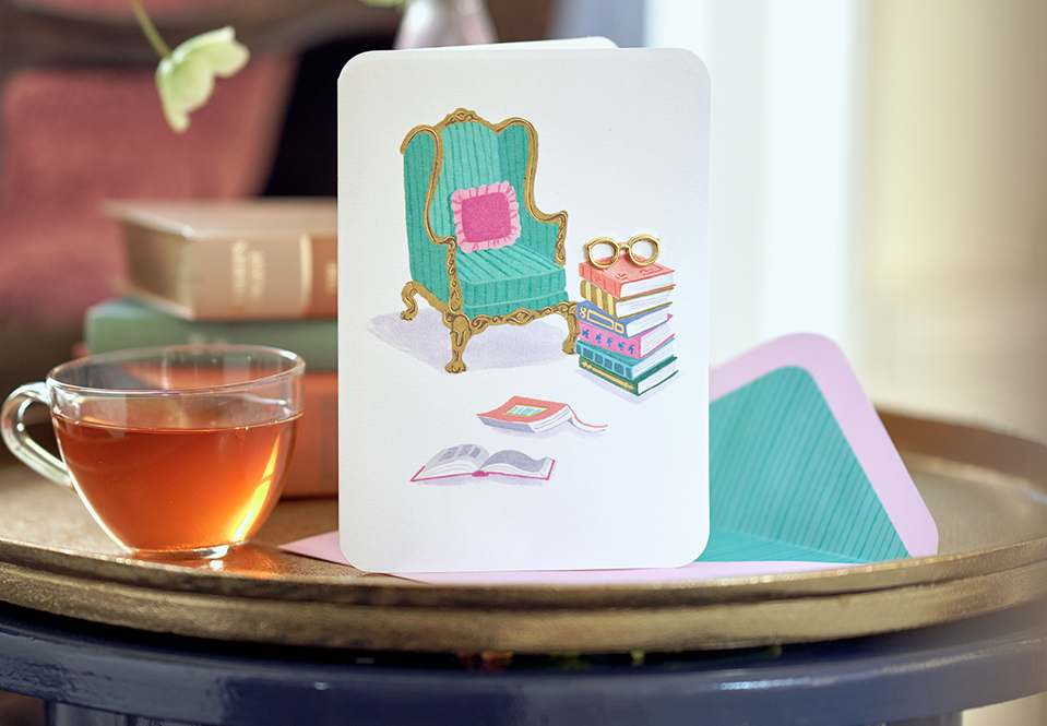 Card with a chair and books on a table