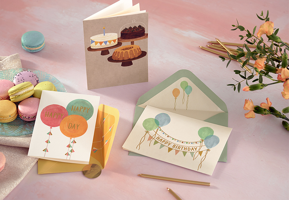 3 birthday cards on a table with macarons