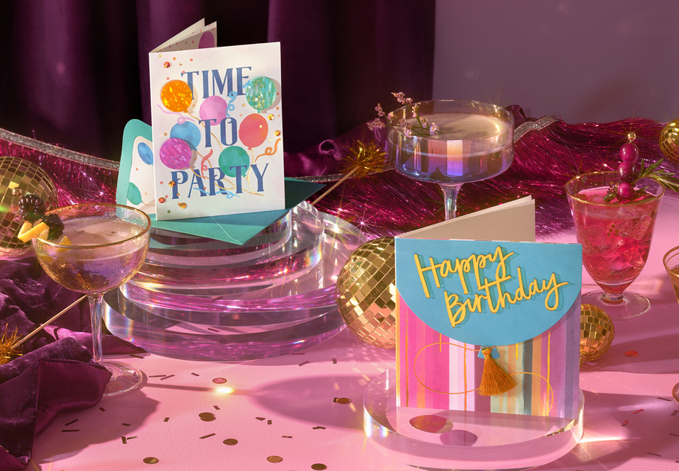 Birthday cards on a pink table with gold confetti
