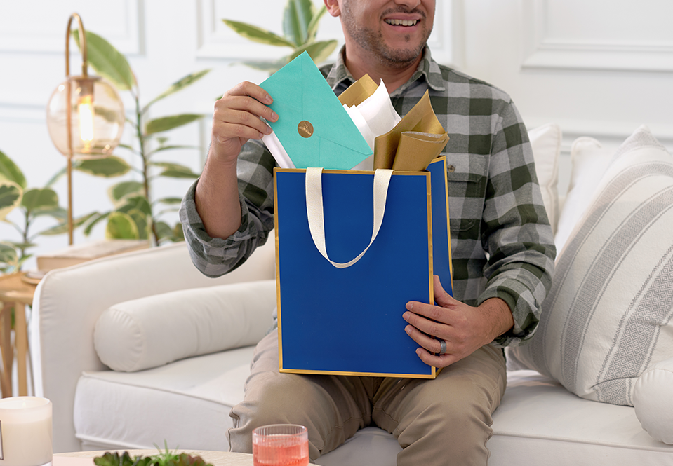 Dad pulling a card out of a blue Papyrus gift bag