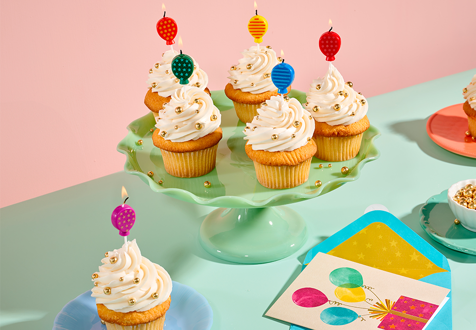 Balloon shaped candles on cupcakes