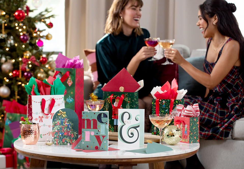 Holiday celebration with table covered in Christmas cards and gifts.